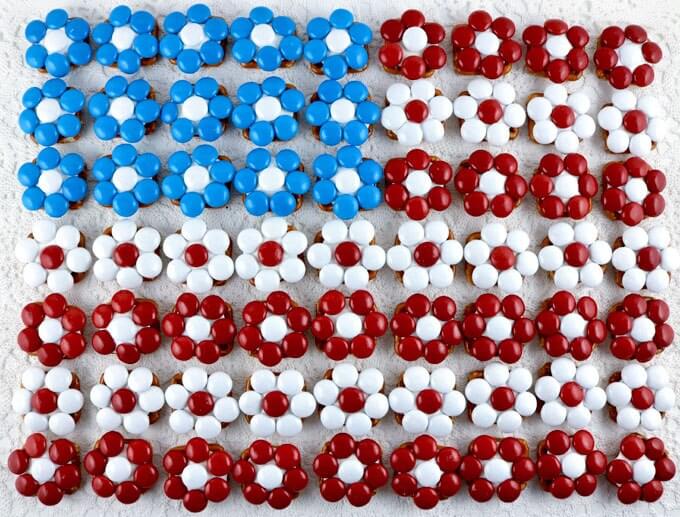 M&Ms in red, white, and blue lie on a salty pretzel in the shape of a flower - the perfect party snack!